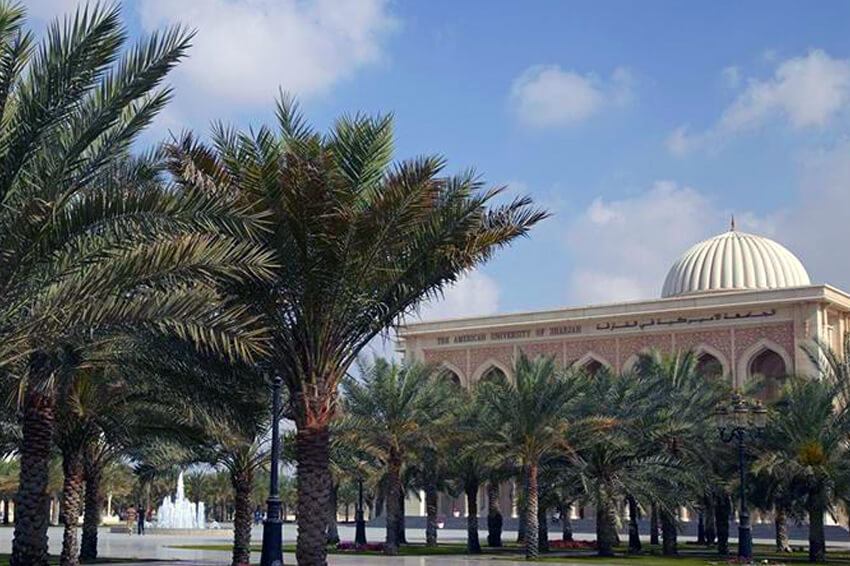 The American University of Sharjah building with palm trees in front